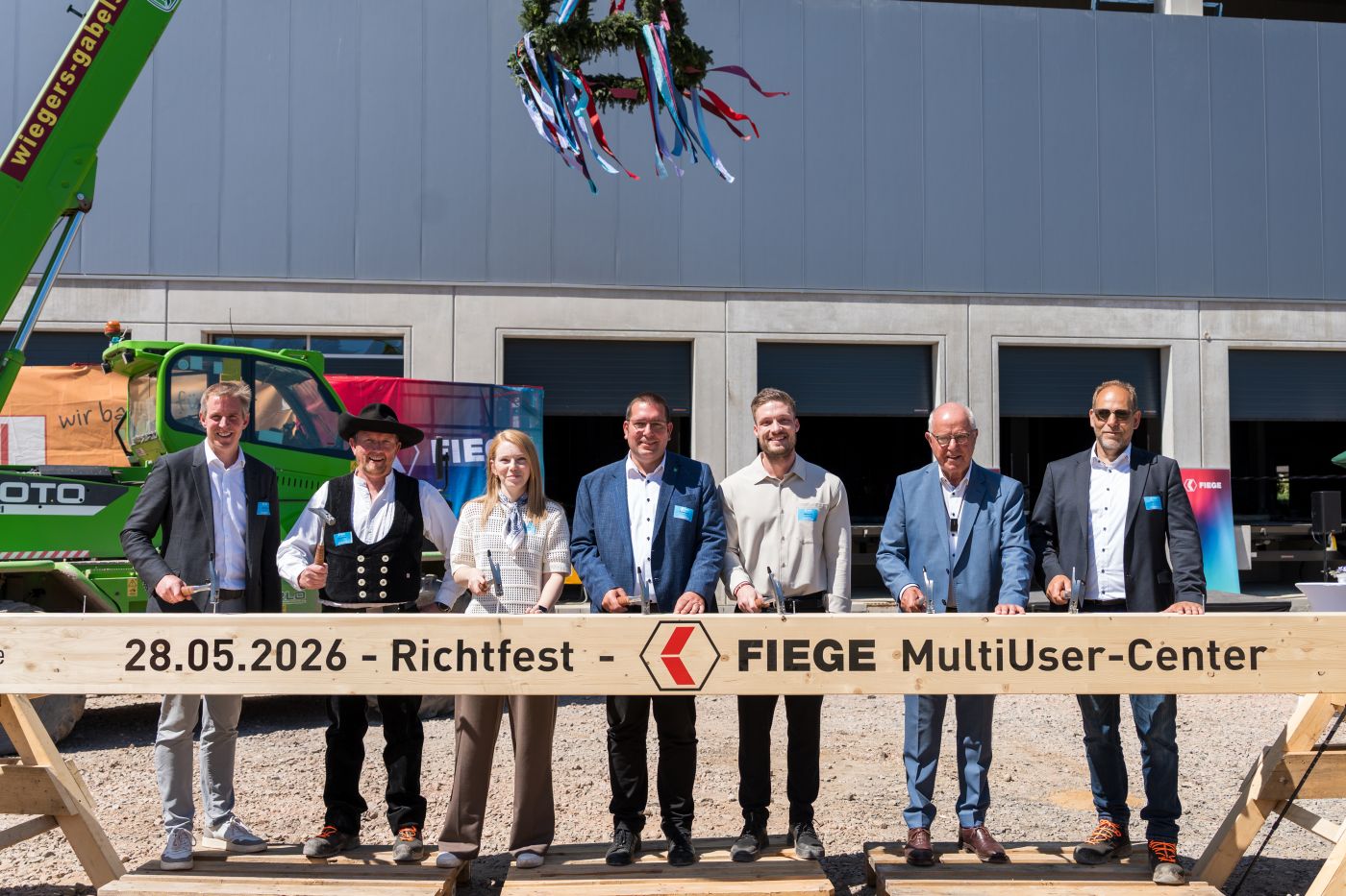 Auf Holz geklopft (v.l.n.r.): Jens Fiege (Co-CEO von Fiege), Rene Jüttner (Zimmermann), Mona Mirek (Fiege Real Estate), Robert Graaf (Bürgermeister der Stadt Hamminkeln), Malte Fink (Fiege Real Estate), Heinz Fiege (Co-CEO der vierten Generation) und Oliver Aust (Max Bögl) beim Richtfest für das neue Fiege-Logistikzentrum in Hamminkeln. (Foto: Fiege)