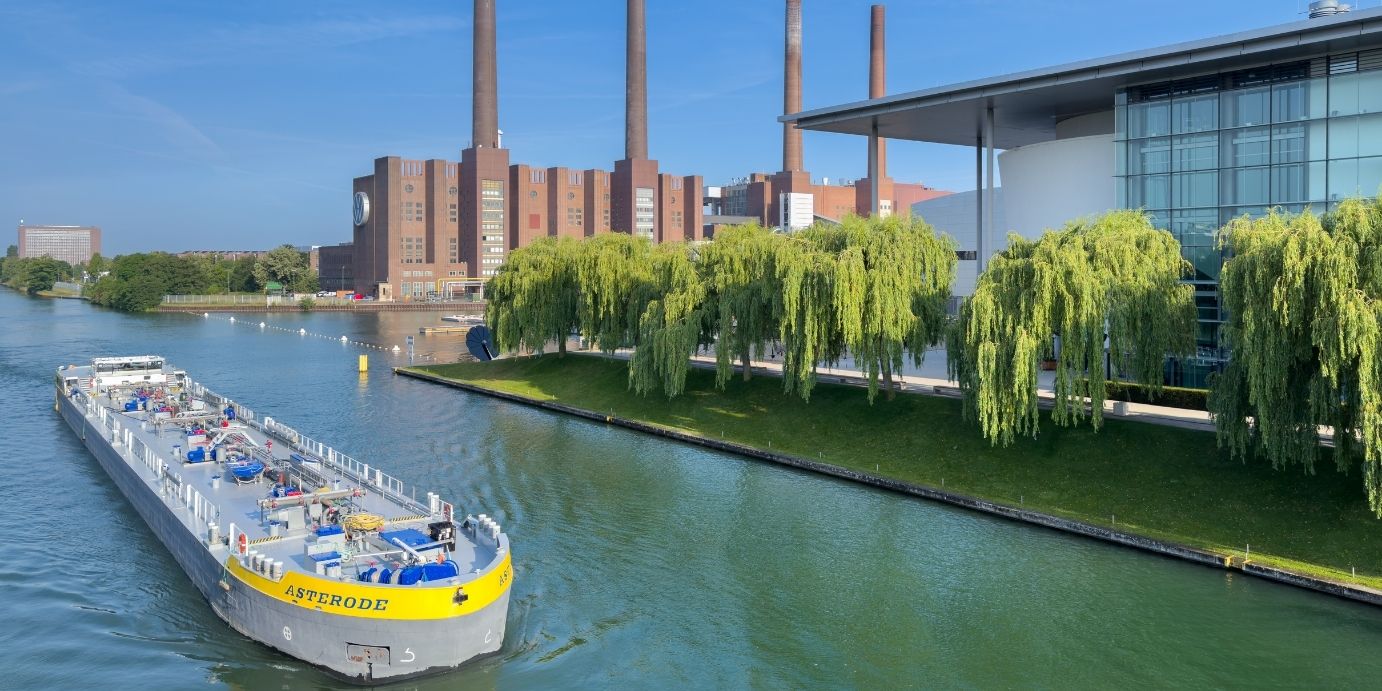 Industrielandschaft des Volkswagen-Stammwerks am Mittellandkanal mit einem Güterschiff zur Darstellung der wassergebundenen Logistik.